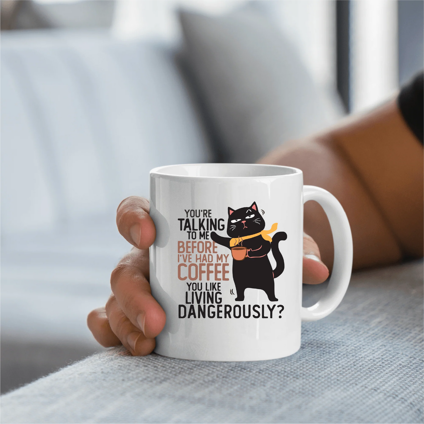 a person holding a coffee mug with a cat on it