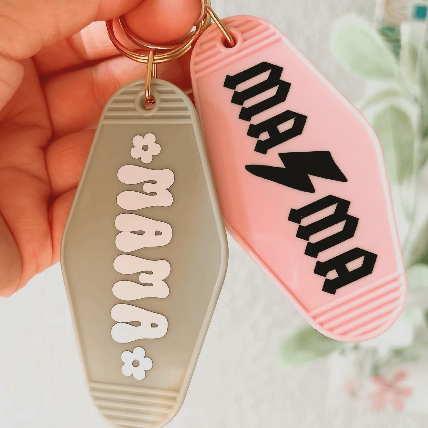 a person holding a pair of key chains in their hand