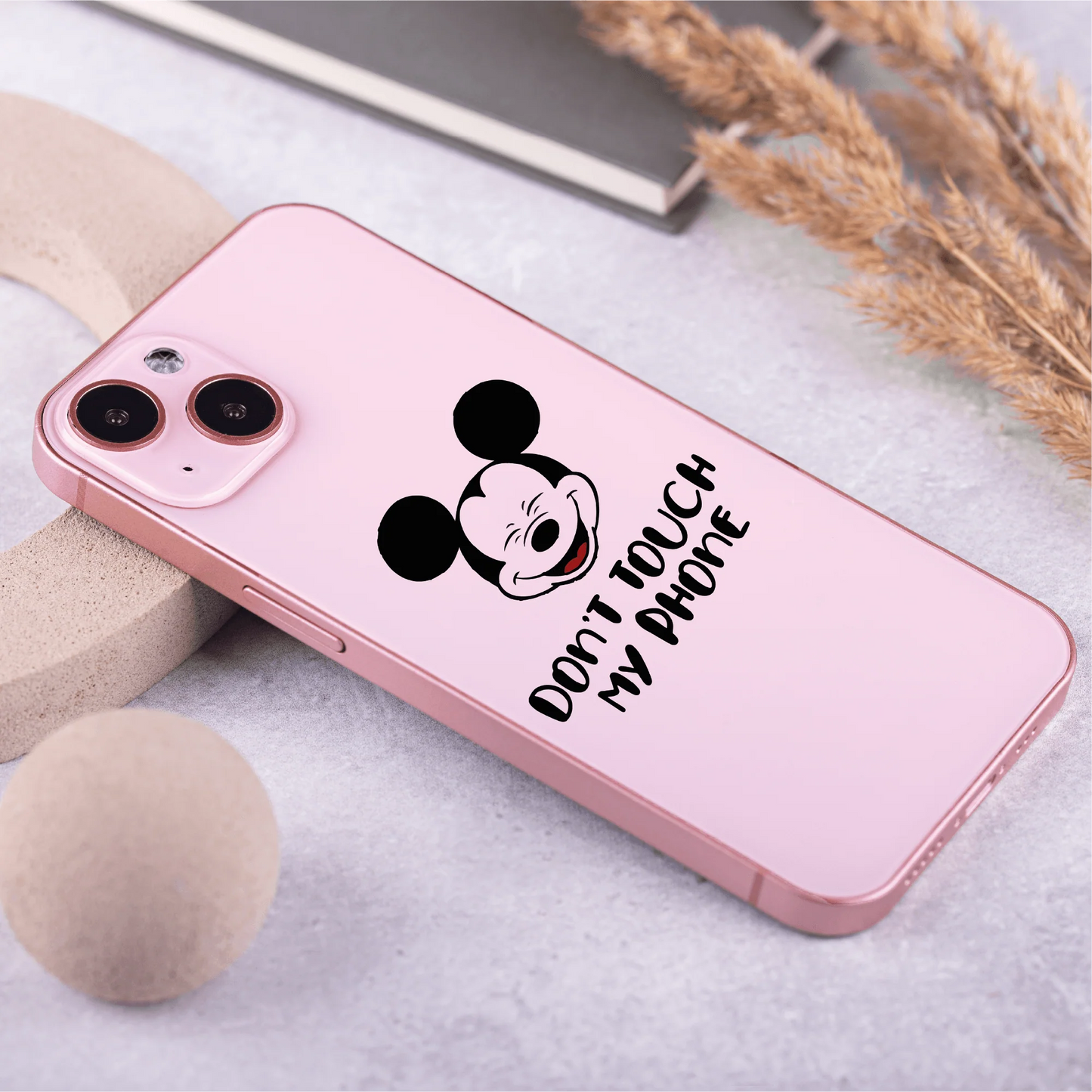 a pink iphone case with a mickey mouse sticker on it
