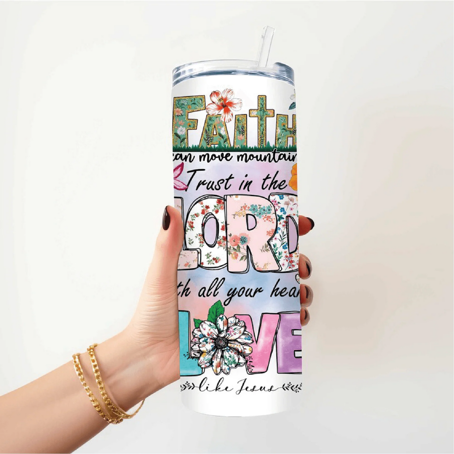 a woman holding a tumbler cup with the words faith on it