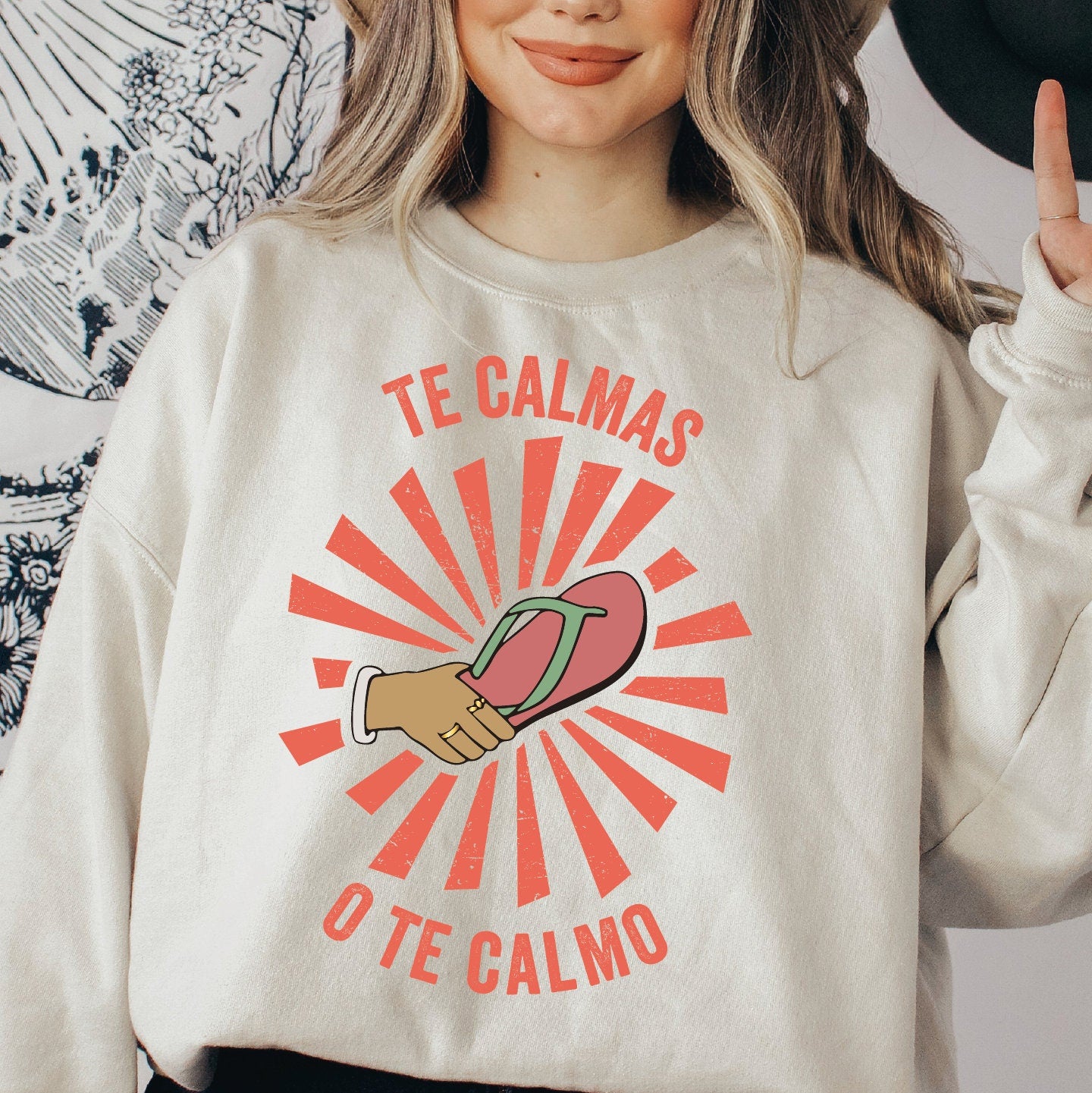 a woman wearing a sweatshirt that says te calmas o&#39;te calmo