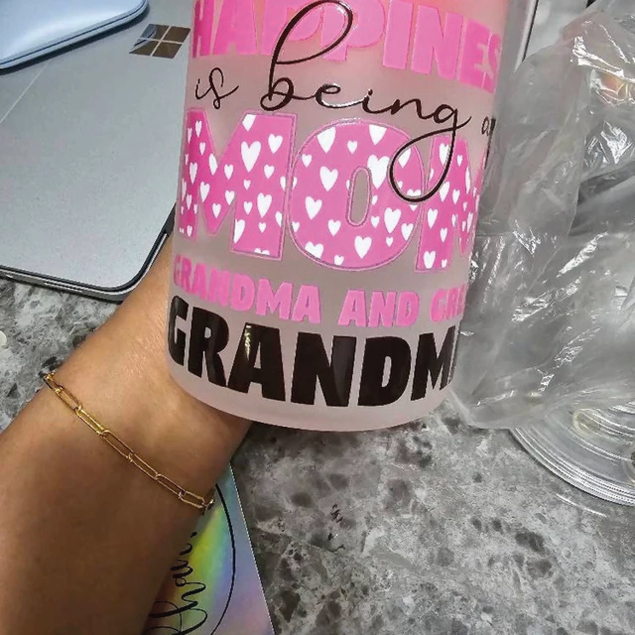 a woman&#39;s hand holding a pink coffee mug